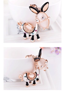 Detailed macro view of donkey pendant with golden alloy base and white enamel finish