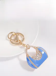 Detailed macro of a blue enamel handbag keychain with white rhinestones and alloy plating
