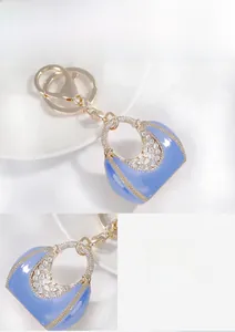 Macro detail of gold-plated alloy keychain with light blue enamel and sparkling rhinestones