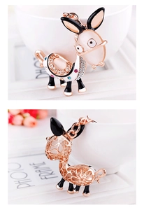 Detail of cartoon donkey keychain with opal stone inlay and rose gold hollow metalwork