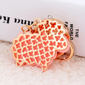Cute cartoon resin sheep keychain with golden hollow metal frame and pink geometric patterns