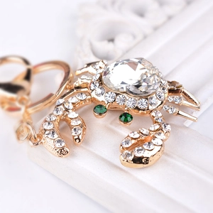 Golden crab keychain with heart-shaped crystal and sparkling rhinestones on pedestal