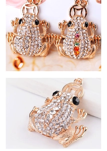 Detailed macro view of golden toad keychains with sparkling white and colorful rhinestones