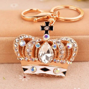 Exquisite gold crown keychain with sparkling rhinestones and a cross on jewelry box