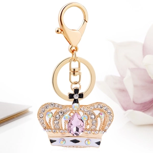 Exquisite golden crown keychain with pink crystals and rhinestones on a white background