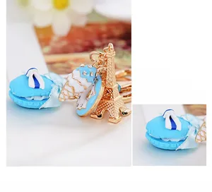 Detailed close-up of blue macaron keychain with golden Eiffel Tower and ice cream charms