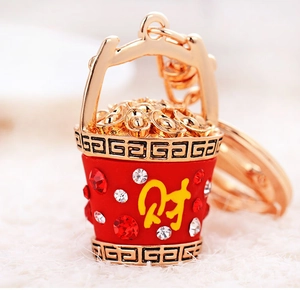 Macro shot of red treasure bucket keychain with gold ingots and crystal rhinestones