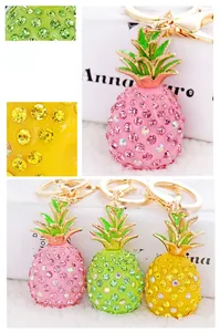 Close-up of sparkling resin pineapple keychains with rhinestones in pink, green, and yellow