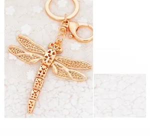 Detailed close-up of dragonfly keychain featuring intricate hollow metal wings in rose gold