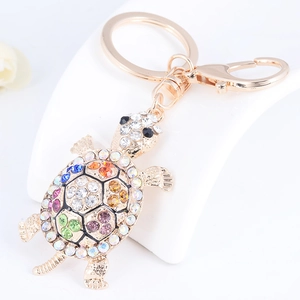 Macro view of colorful rhinestone turtle keychain with polished gold-plated metal finish