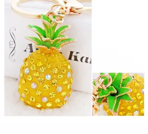 Detail of sparkling resin pineapple keychain with yellow rhinestones and green enamel leaves