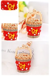 Close-up of golden fortune bucket keychain with red enamel, rhinestones and gold ingots