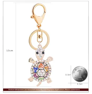 Creative turtle keychain with colorful rhinestones shown next to a coin for size reference