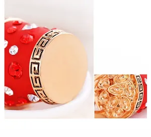 Detail of red rhinestone car keychain with golden Greek key pattern and luxury finish