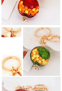 Detail of red enamel pomegranate keychain with sparkling crystal seeds and gold ring