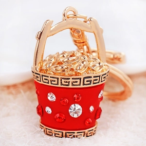 Lucky Chinese fortune bucket keychain with gold ingots and red rhinestones on white