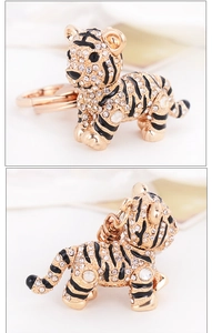 Détail macro du porte-clés tigre en cristal avec placage or et rayures en émail noir