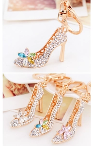 Détail de porte-clés escarpin doré avec strass scintillants et accents floraux en gemmes