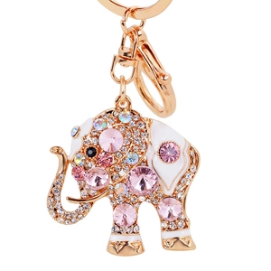 Porte-clés éléphant doré avec strass roses et émail blanc sur fond blanc