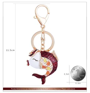 Détail d'un porte-clés en forme de poisson avec émail rouge et fermoir mousqueton doré