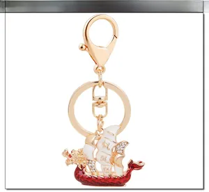 Macro view of gold-plated dragon boat keychain with red enamel and sparkling rhinestones