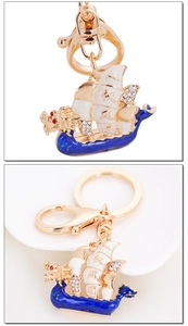 Detail of dragon boat keychain with blue enamel, crystals and Chinese blessing