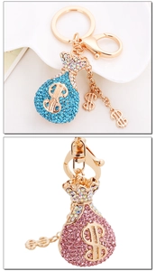 Details von rosa und blauen Strass-Geldbeutel-Schlüsselanhängern mit glitzernden Dollarzeichen