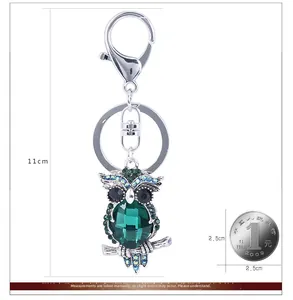 Détail du porte-clés hibou avec gemme vert foncé et strass bleus scintillants