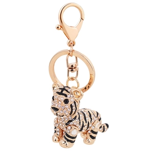 Porte-clés tigre doré avec cristaux blancs et rayures en émail noir sur fond blanc