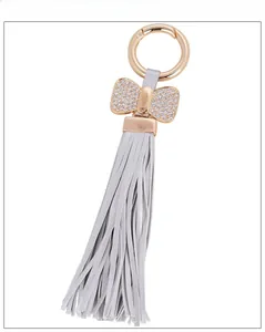 Detail showing bowknot charm with sparkling rhinestones and long leather tassels