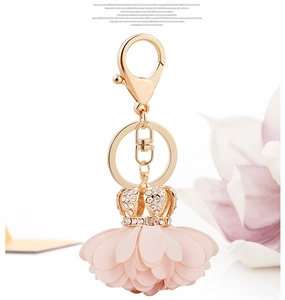 Detail of pink fabric flower keychain with sparkling crystal gold crown for handbags