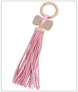 Close-up of pink leather tassel keychain with sparkling rhinestone bow and rose gold hardware