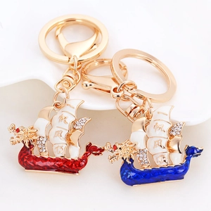 Golden dragon boat keychains with colorful enamel sails and rhinestone details