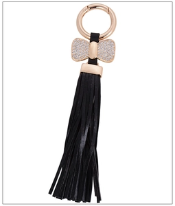 Detail shot of black leather tassel keychain with a sparkling rhinestone bow charm