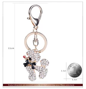 Vue détaillée du porte-clés caniche en strass avec dimensions à côté d'une pièce
