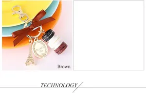Detailed view of macaroon keychain with Eiffel Tower charm and a brown ribbon bow