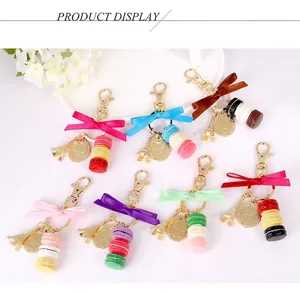 Various macaron cake keychains with Eiffel Tower charms and bows on a white background