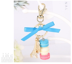 Detail showing colorful macaron pendants with Eiffel Tower and blue satin bow on a keychain
