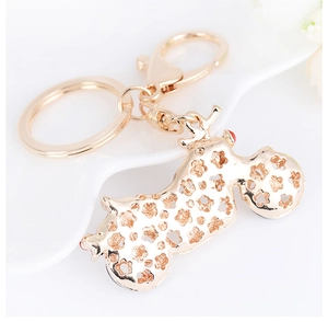 Vue macro d'un porte-clés moto en or champagne avec motif floral évidé et fermoir mousqueton