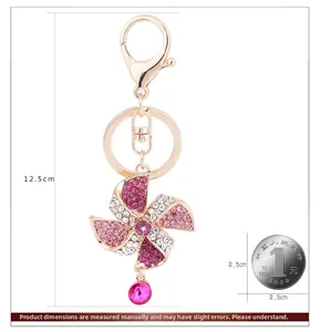 Détail du porte-clés moulin à vent doré rose avec cristaux roses et mesure de 12,5 cm
