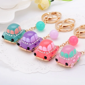Détail de porte-clés voiture en strass colorés en sarcelle, violet, corail et rose