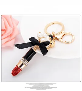 Détail d'un porte-clés rouge strassé en forme de rouge à lèvres avec perles blanches