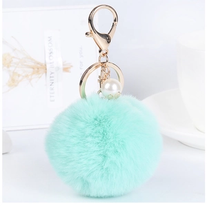 Close-up of mint green plush keychain with soft faux fur and elegant pearl detail