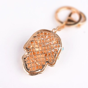 Rose gold Hamsa hand keychain with hollow floral pattern and colorful gemstone accents