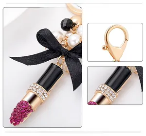 Détails macro du porte-clés rouge à lèvres élégant avec perles et nœud en satin noir