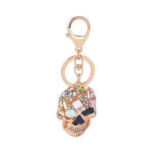 Rose gold skull keychain with colorful rhinestones on a white background