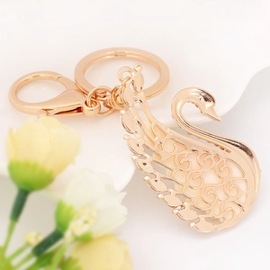 Eleganter roségoldener Schwan Schlüsselanhänger mit hohlem Filigran auf weißer Keramik