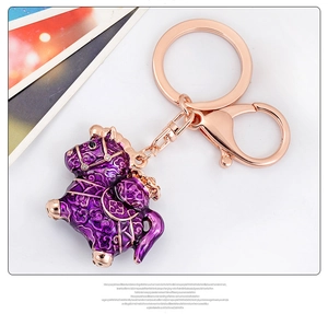 Detailed close-up of purple enamel pony keychain with golden patterns and lobster clasp