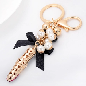 Porte-clés rouge à lèvres élégant avec perles et nœud noir sur fond blanc épuré
