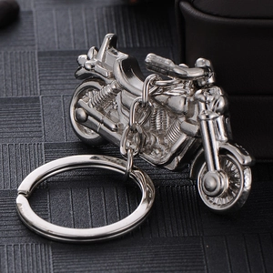 Sleek silver zinc alloy motorcycle keychain with realistic engine details on black mat